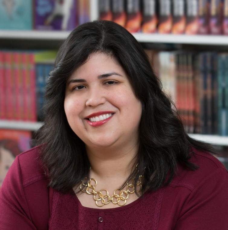 Linda Camacho smiling in front of shelves of books